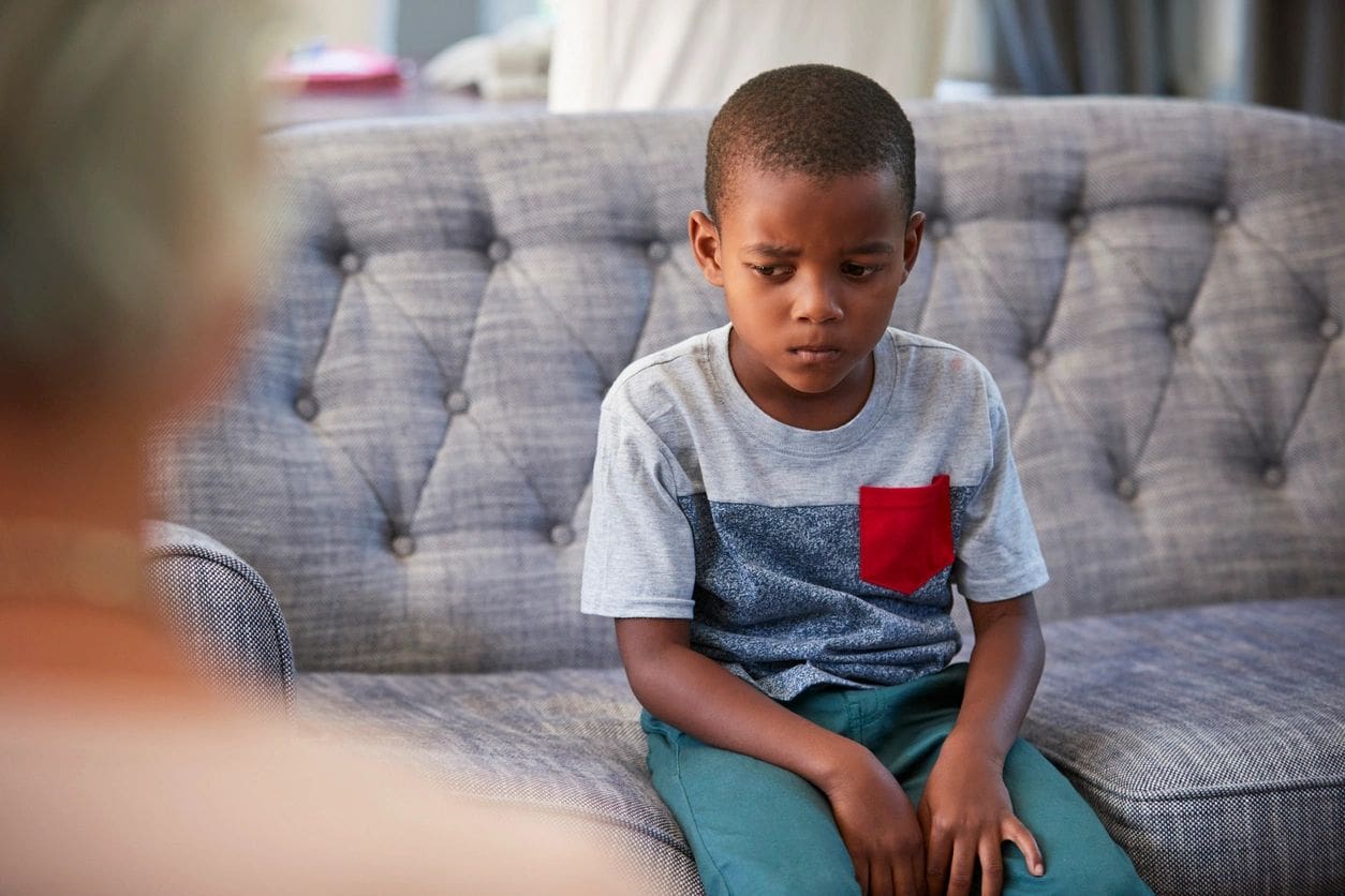 A young boy sitting on top of a couch.