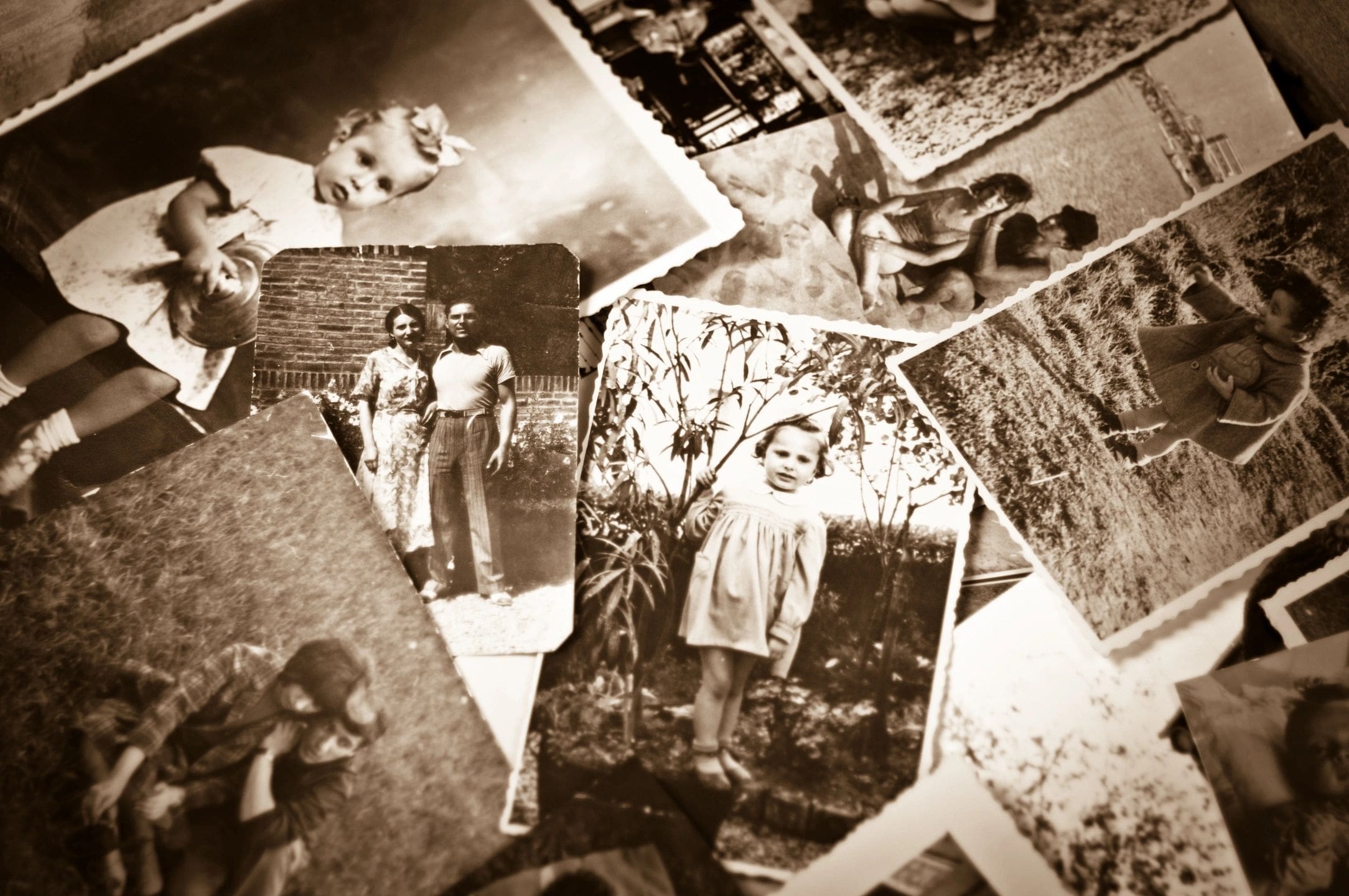 A pile of old photographs with people in them.